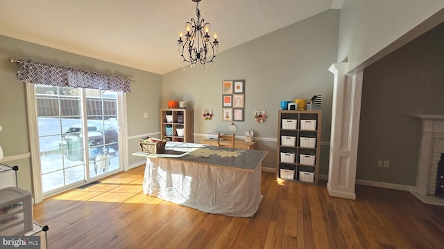 office with wood-type flooring, lofted ceiling, and a chandelier