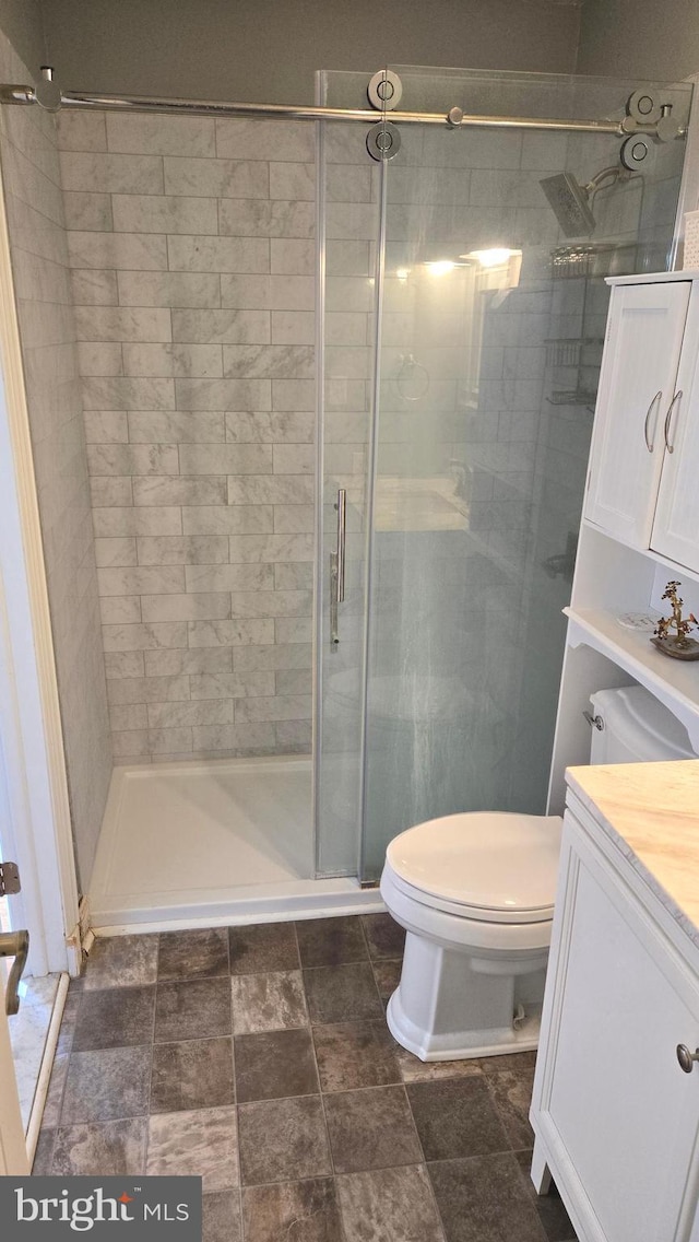 bathroom featuring vanity, toilet, and an enclosed shower