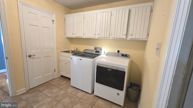 clothes washing area featuring cabinets, independent washer and dryer, sink, and light tile patterned floors