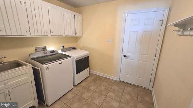 laundry area featuring washer and clothes dryer, light tile patterned floors, cabinets, and sink