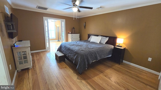 bedroom with ceiling fan, light hardwood / wood-style floors, and ornamental molding