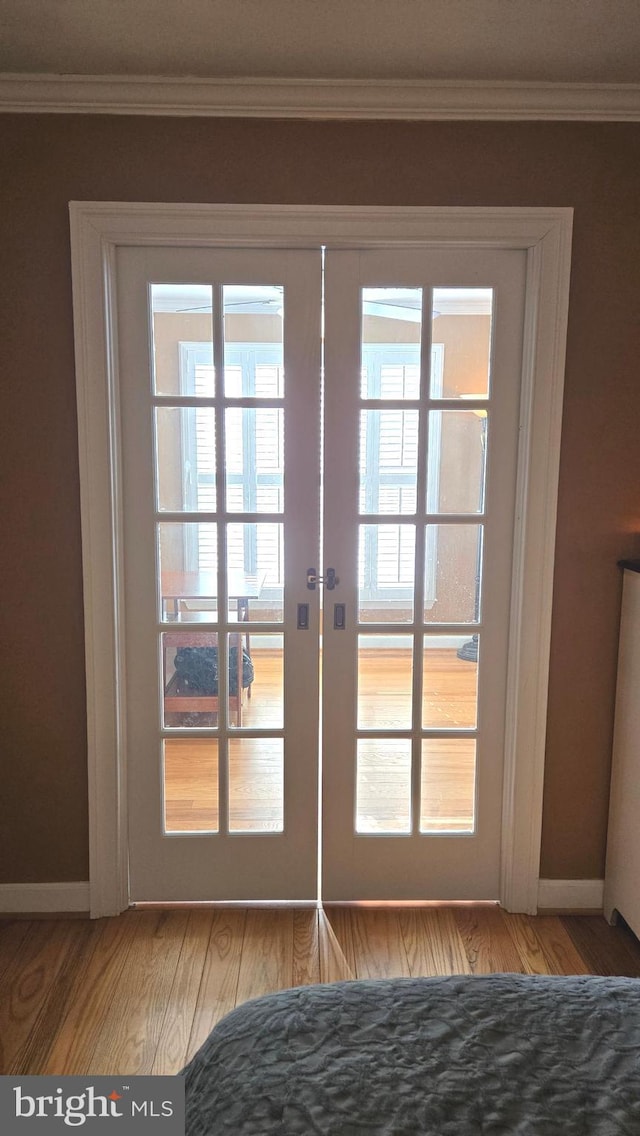 doorway to outside with french doors, hardwood / wood-style flooring, and ornamental molding