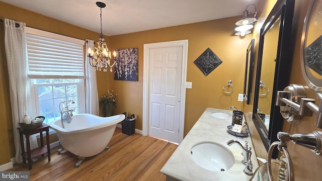 bathroom featuring a chandelier, vanity, a bath, and wood-type flooring