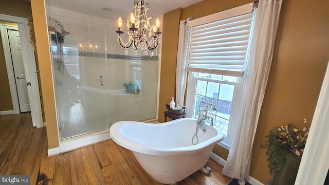 bathroom with plus walk in shower, wood-type flooring, and an inviting chandelier