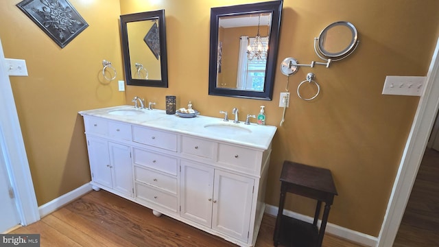 bathroom featuring vanity, wood-type flooring, and a notable chandelier