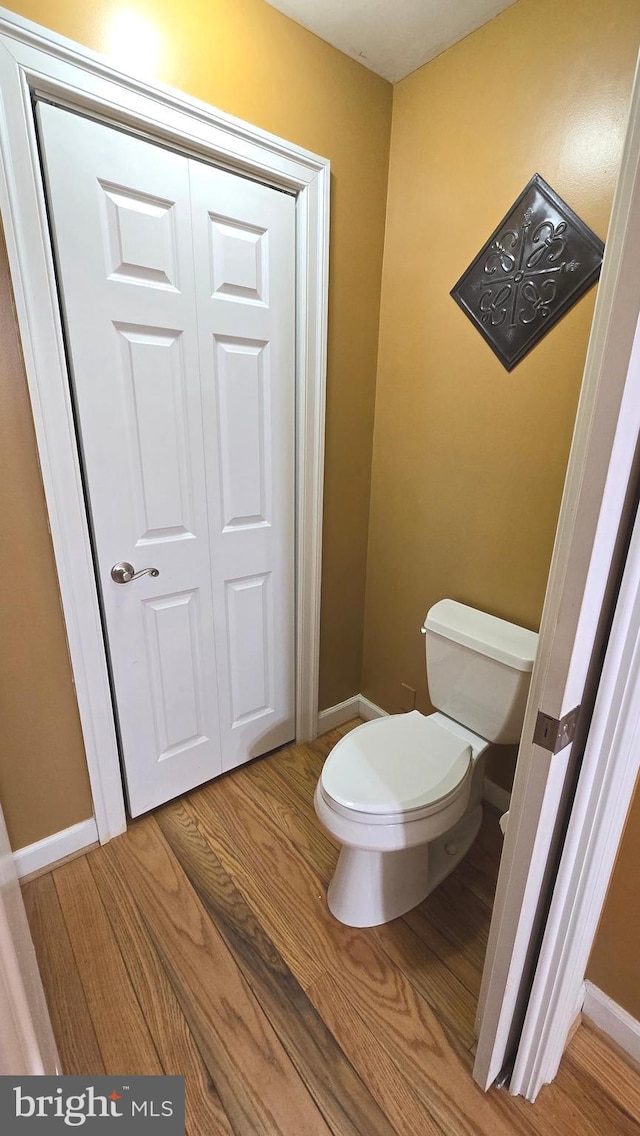 bathroom with hardwood / wood-style floors and toilet