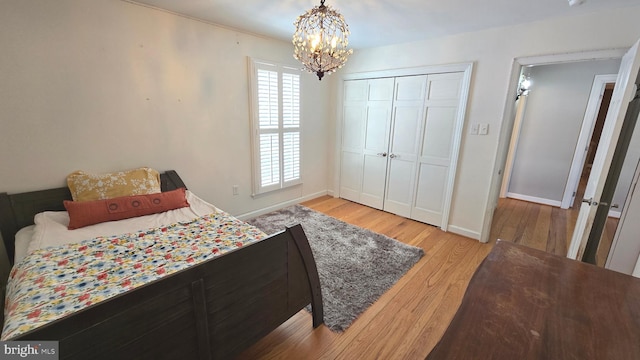 bedroom with a chandelier, light hardwood / wood-style floors, and a closet