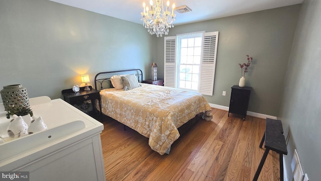 bedroom featuring wood-type flooring and an inviting chandelier