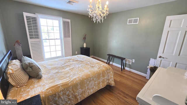 bedroom with wood-type flooring and a notable chandelier