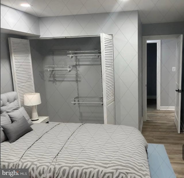 bedroom with hardwood / wood-style floors and a closet