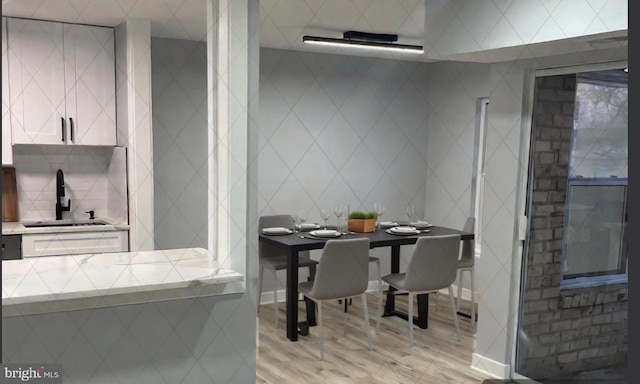 dining area featuring sink and light hardwood / wood-style flooring