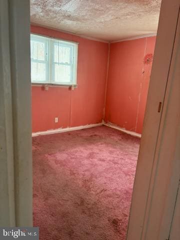 unfurnished room featuring a textured ceiling and carpet floors