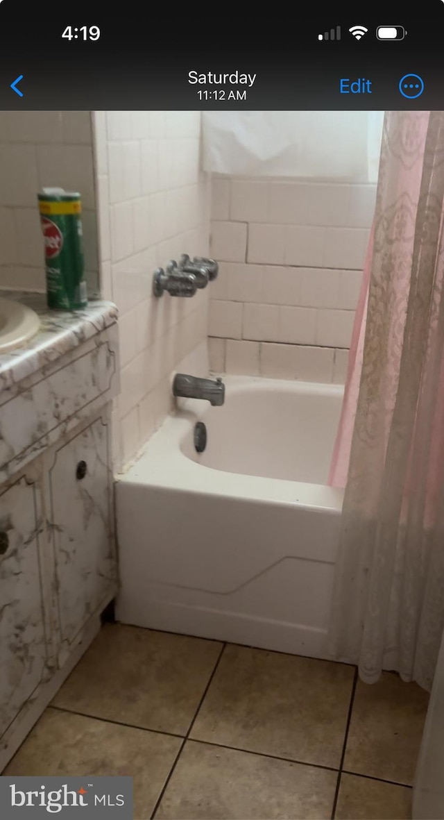 bathroom with tile patterned flooring and shower / bath combination with curtain