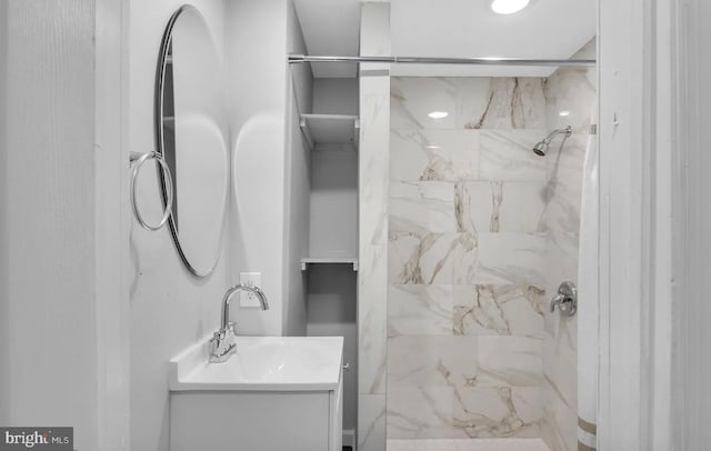 bathroom featuring vanity and tiled shower