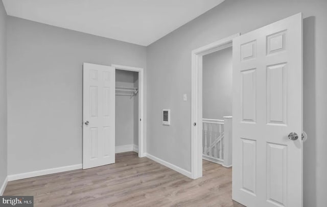 unfurnished bedroom with a closet and light hardwood / wood-style flooring