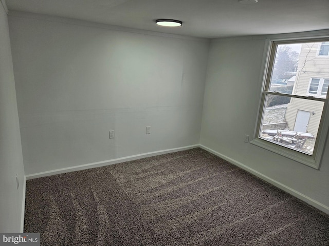 spare room featuring dark carpet