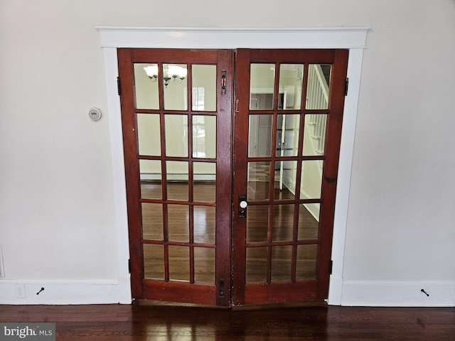 entryway featuring french doors, baseboard heating, and dark wood-type flooring