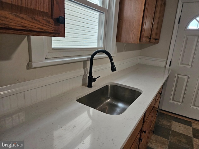 kitchen featuring sink and light stone countertops