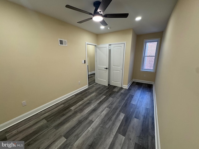 unfurnished bedroom with ceiling fan, a closet, and dark hardwood / wood-style flooring