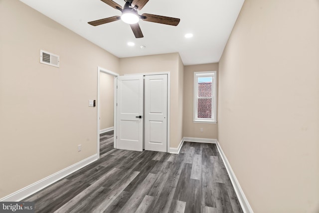 unfurnished bedroom with dark wood-type flooring, ceiling fan, and a closet