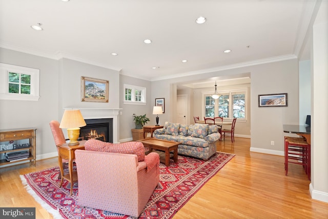 living room with light wood-type flooring and ornamental molding