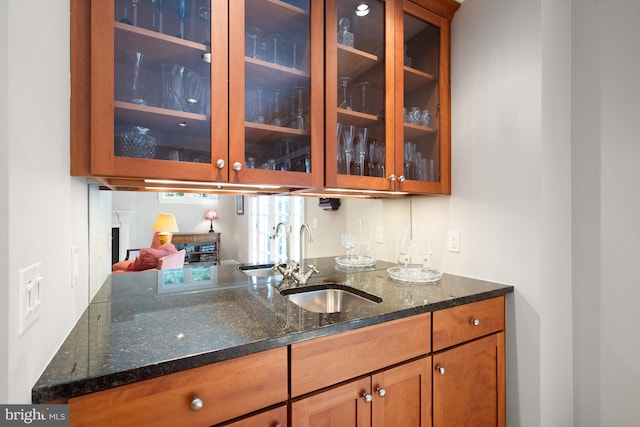 bar featuring dark stone countertops and sink