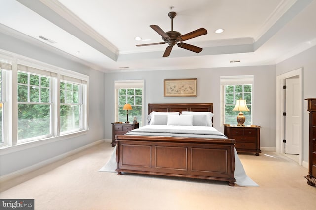 bedroom with ceiling fan, a raised ceiling, light carpet, and crown molding