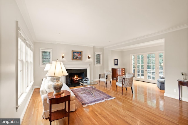 living room with french doors, crown molding, and light hardwood / wood-style flooring