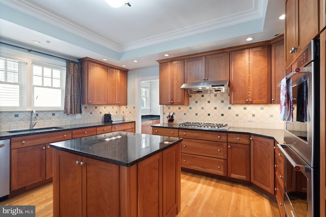 kitchen featuring a kitchen island, crown molding, sink, and appliances with stainless steel finishes