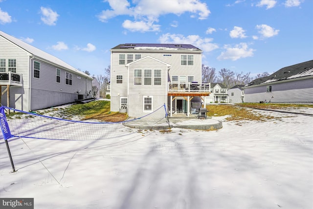 rear view of property featuring solar panels and a deck