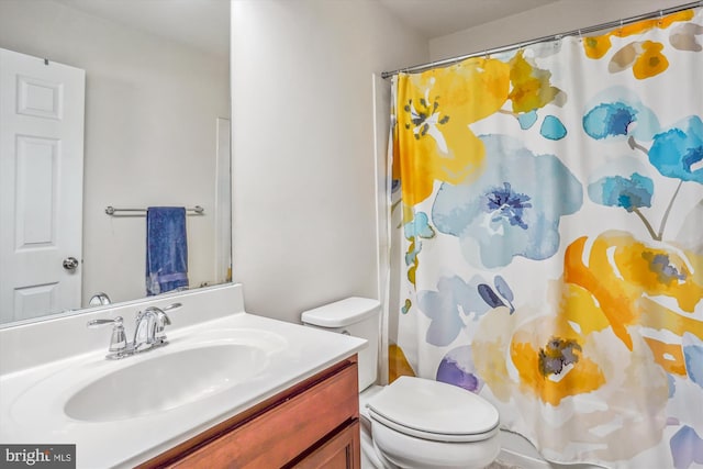 bathroom featuring toilet, vanity, and a shower with curtain