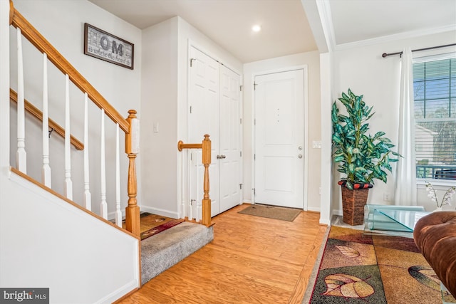 entryway featuring light hardwood / wood-style floors and ornamental molding