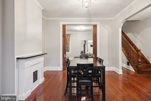 dining room with dark wood-type flooring and ornamental molding