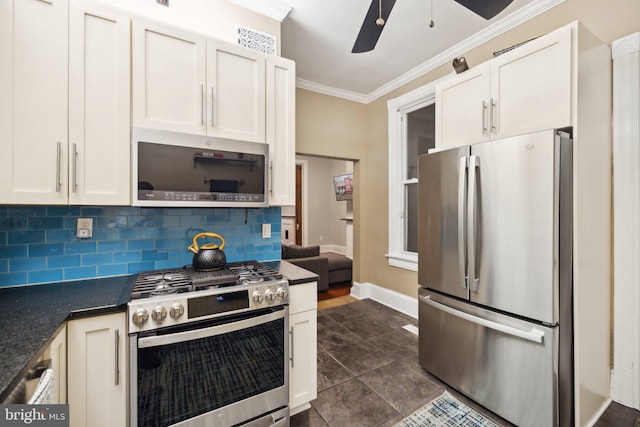 kitchen with crown molding, ceiling fan, decorative backsplash, white cabinetry, and stainless steel appliances