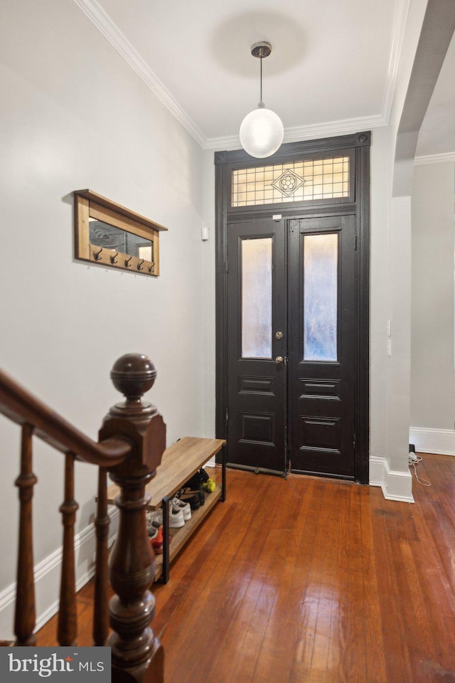 foyer with ornamental molding, french doors, and dark wood-type flooring