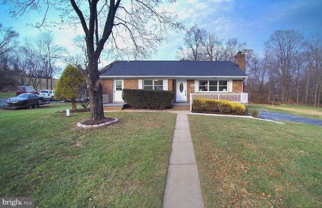 ranch-style house with covered porch and a front yard