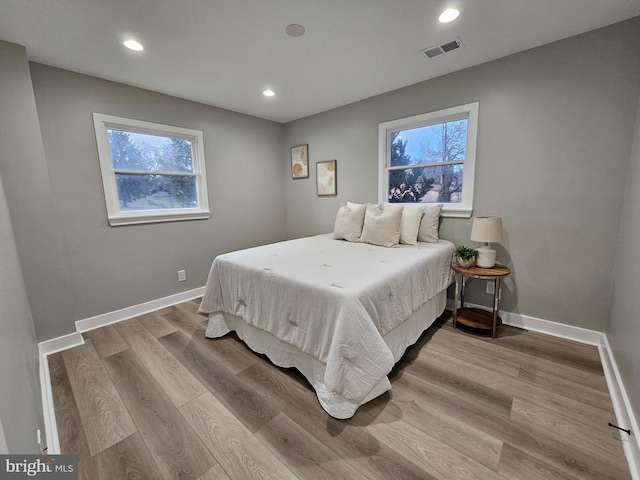 bedroom with light wood-type flooring and multiple windows