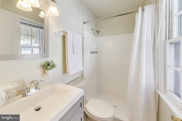 bathroom featuring toilet, vanity, and a shower with shower curtain