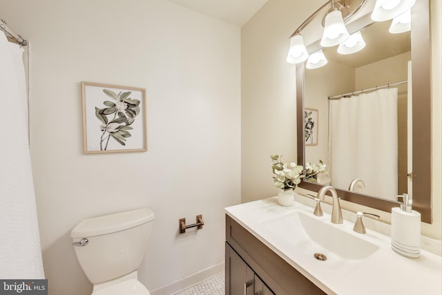 bathroom with toilet, tile patterned flooring, and vanity