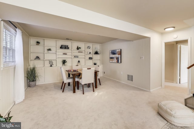 dining area featuring built in shelves and light carpet