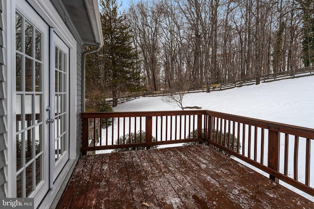 snow covered deck featuring french doors