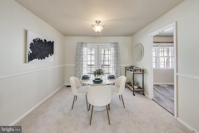 dining room featuring light colored carpet and french doors