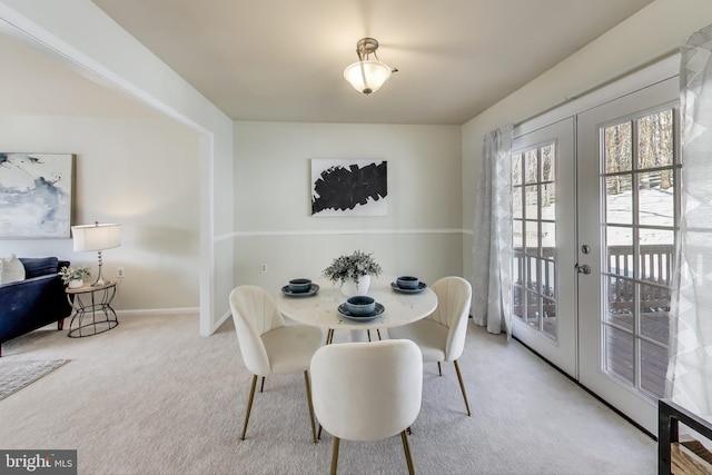 carpeted dining space featuring french doors