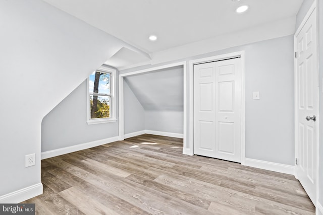 bonus room featuring light wood-type flooring and lofted ceiling