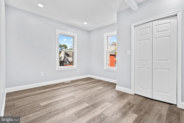 unfurnished bedroom with a closet and light hardwood / wood-style flooring