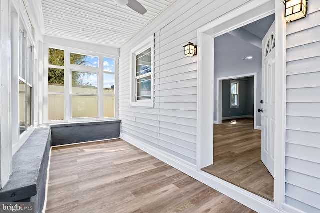 unfurnished sunroom featuring ceiling fan