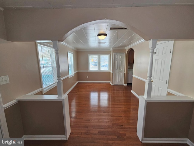 unfurnished dining area with ornate columns, dark hardwood / wood-style floors, and ornamental molding