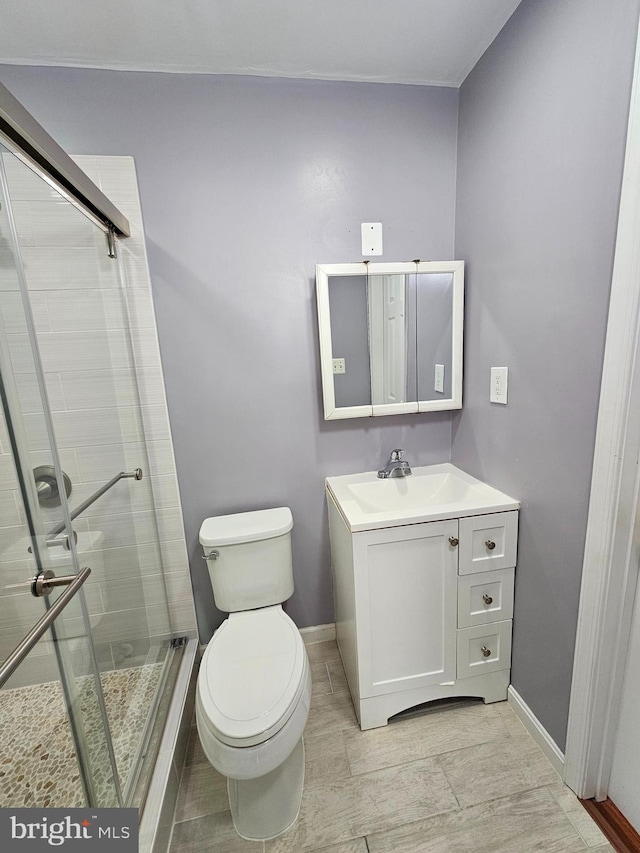 bathroom featuring vanity, an enclosed shower, and toilet