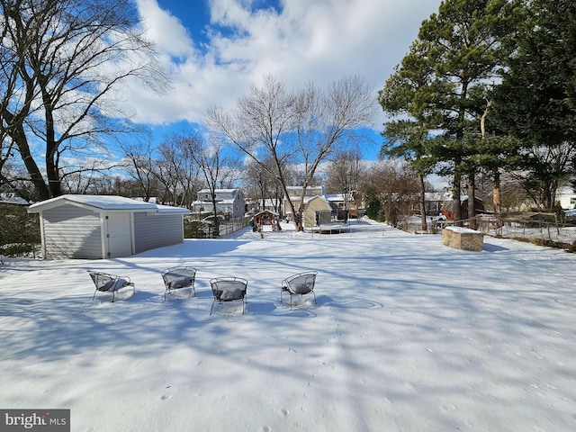 yard layered in snow with a storage unit