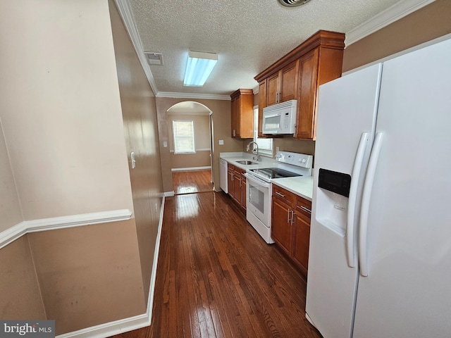 kitchen with white appliances, sink, dark hardwood / wood-style floors, ornamental molding, and a textured ceiling